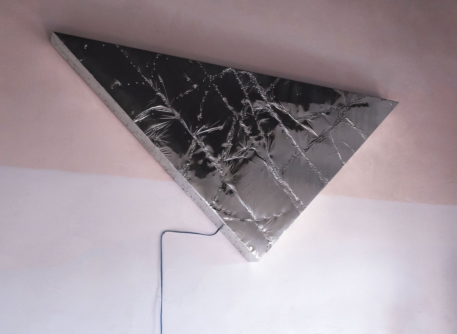 Triangle #1, 2020 | silver reflective mylar film, aluminum pins and plywood, subwoofer, amplifier. 240 × 170 × 170 cm